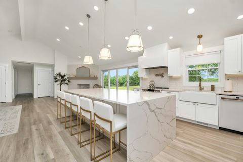 Renovated kitchen with a marble island and white cabinetry