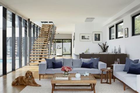 Open living room with staircase and large windows after renovation